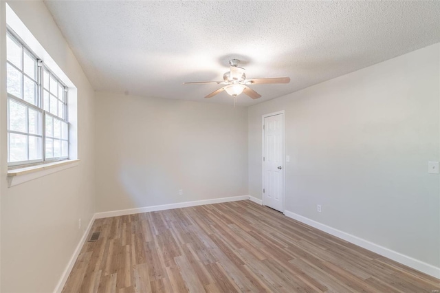 unfurnished room featuring ceiling fan, a textured ceiling, and light hardwood / wood-style flooring