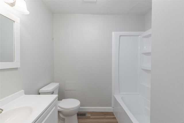 full bathroom with toilet, bathing tub / shower combination, hardwood / wood-style floors, vanity, and a textured ceiling