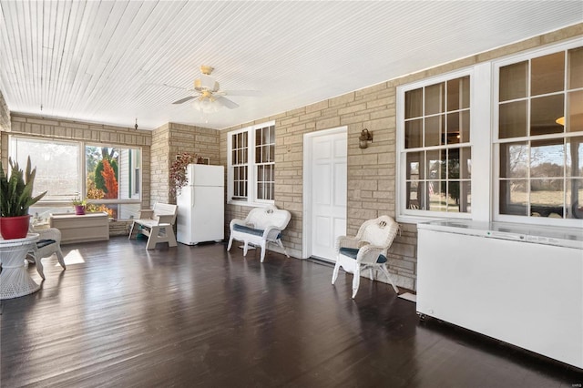 sunroom featuring radiator and ceiling fan