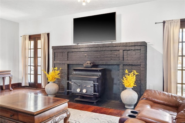 living room featuring a wood stove, hardwood / wood-style floors, and a fireplace