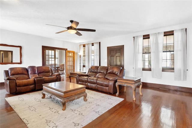 living room with dark wood-type flooring and ceiling fan