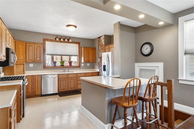 kitchen with sink, a center island, a kitchen bar, and stainless steel appliances