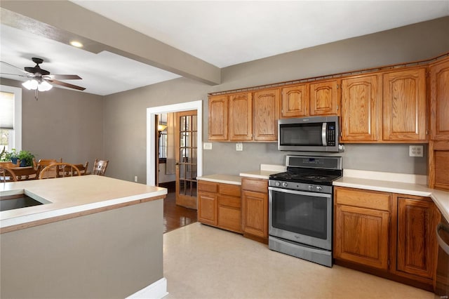 kitchen with beam ceiling, light hardwood / wood-style flooring, sink, appliances with stainless steel finishes, and ceiling fan