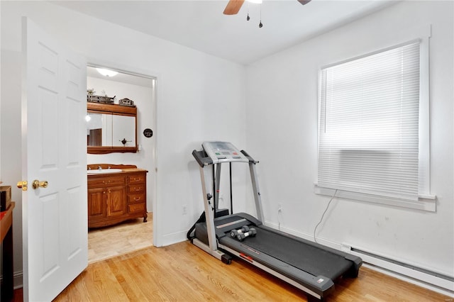 exercise area featuring light hardwood / wood-style flooring, sink, a baseboard radiator, and ceiling fan