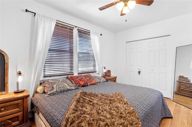 bedroom with a closet, hardwood / wood-style floors, and ceiling fan