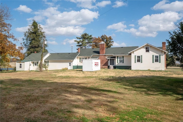 rear view of property with a lawn