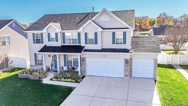 view of front facade featuring covered porch, a garage, and a front yard