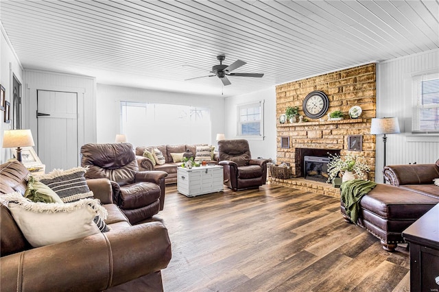 living room featuring a brick fireplace, hardwood / wood-style floors, ceiling fan, and wood ceiling