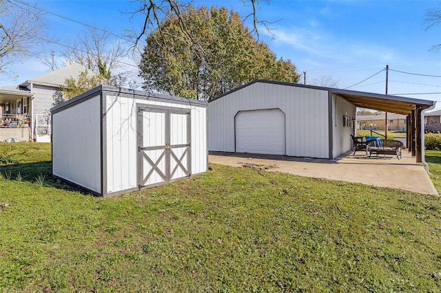 view of outdoor structure with a garage, a carport, and a yard