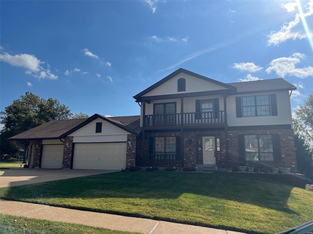 view of front of property with a balcony, a front lawn, and a garage