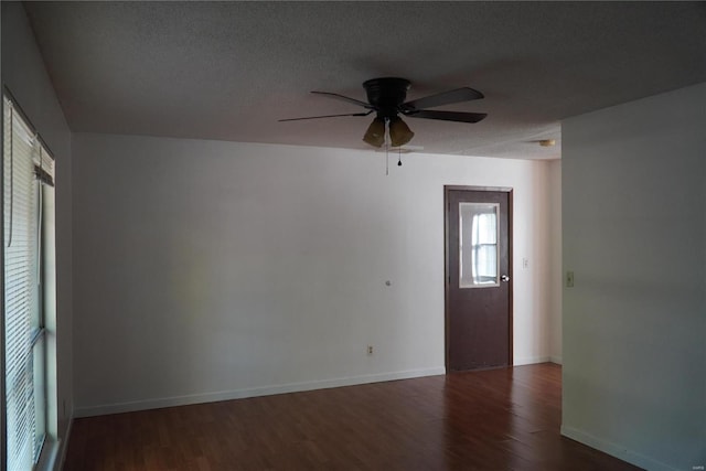 spare room with dark hardwood / wood-style floors, a textured ceiling, and ceiling fan