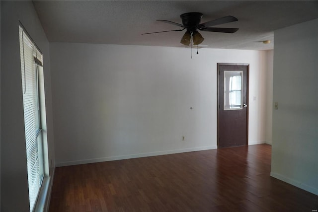 empty room with a textured ceiling, dark hardwood / wood-style floors, and ceiling fan