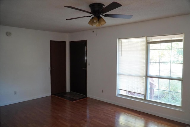 empty room featuring a wealth of natural light, a textured ceiling, wood-type flooring, and ceiling fan