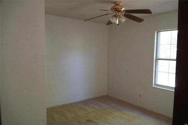 empty room with light carpet, a textured ceiling, plenty of natural light, and ceiling fan