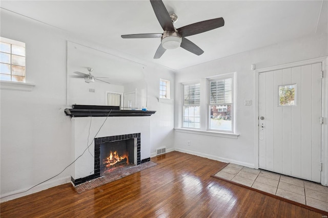 foyer featuring a tiled fireplace, ceiling fan, and hardwood / wood-style flooring