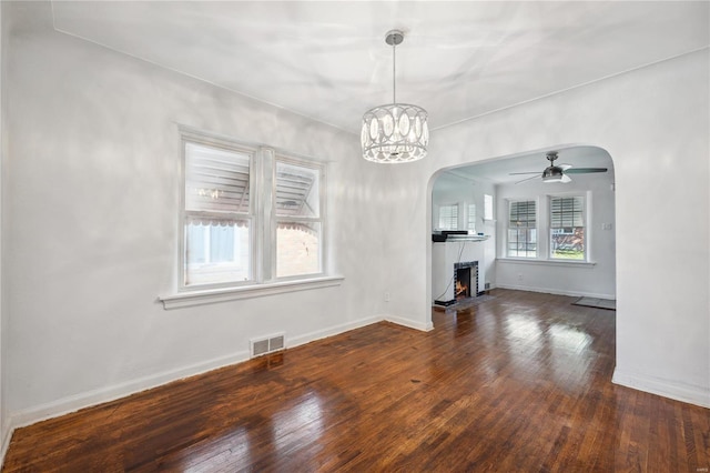 interior space featuring ceiling fan with notable chandelier and dark hardwood / wood-style floors