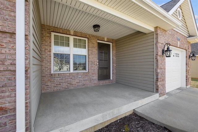 view of exterior entry with a garage and covered porch