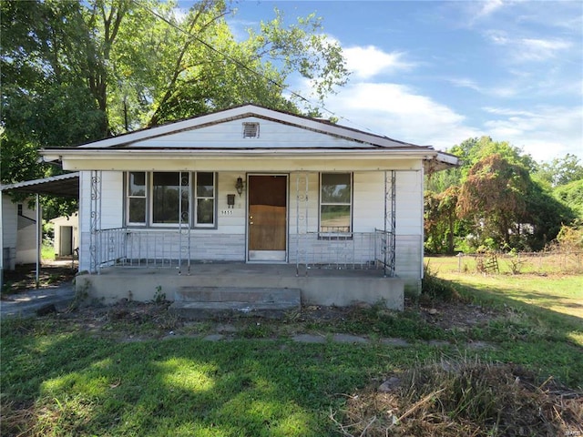 bungalow-style home featuring a front lawn and covered porch