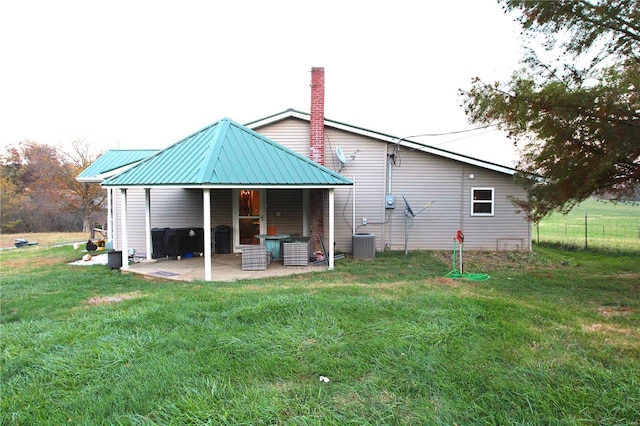 back of property with a patio, a lawn, and central air condition unit