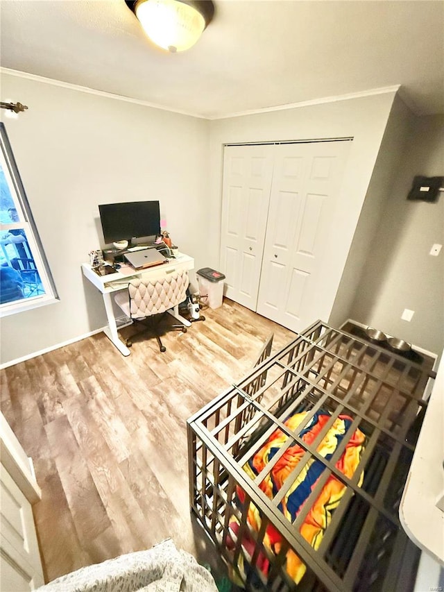 bedroom with a closet, wood-type flooring, and crown molding