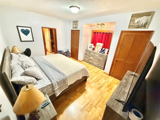 bedroom featuring a textured ceiling and hardwood / wood-style flooring