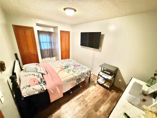 bedroom featuring hardwood / wood-style floors and a textured ceiling