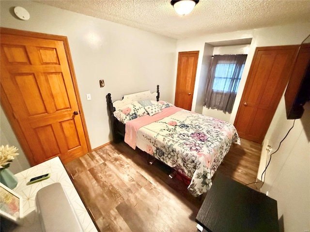 bedroom featuring light hardwood / wood-style flooring and a textured ceiling