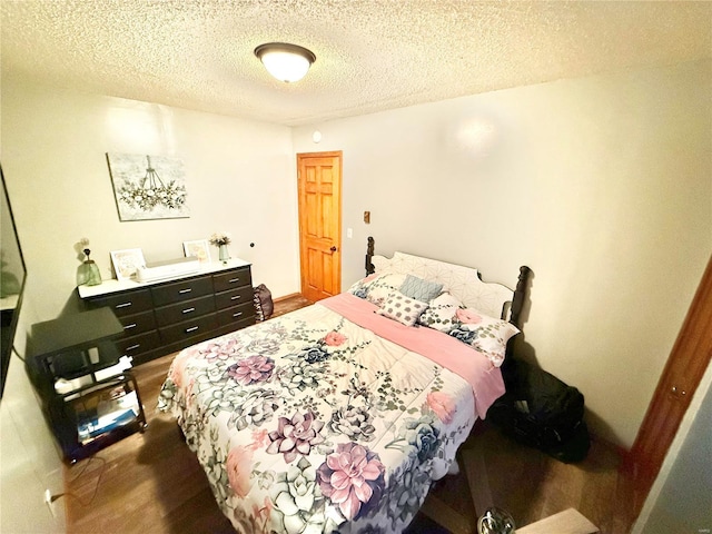 bedroom with hardwood / wood-style floors and a textured ceiling