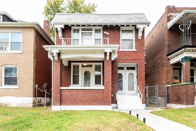 view of front of home featuring a balcony, a front yard, and ceiling fan