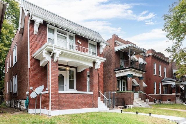 view of front of home with a balcony and a front lawn