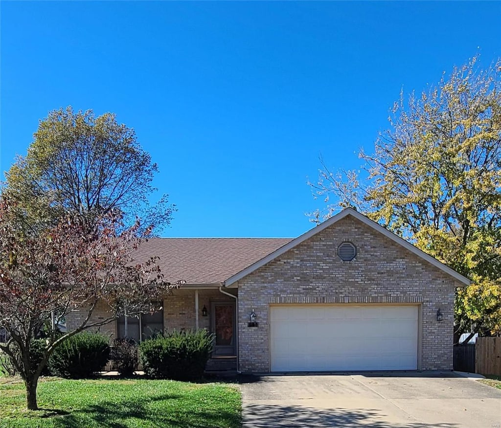 ranch-style home featuring a garage and a front lawn