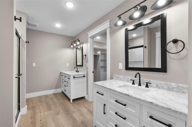 bathroom with vanity, an enclosed shower, and hardwood / wood-style flooring