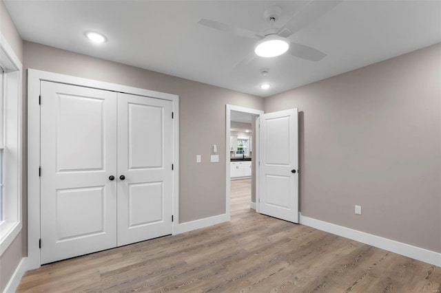 unfurnished bedroom featuring a closet, light wood-type flooring, and ceiling fan