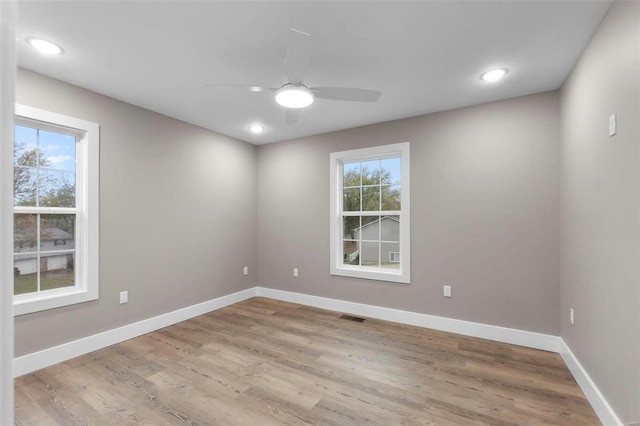 unfurnished room featuring light hardwood / wood-style flooring, ceiling fan, and plenty of natural light