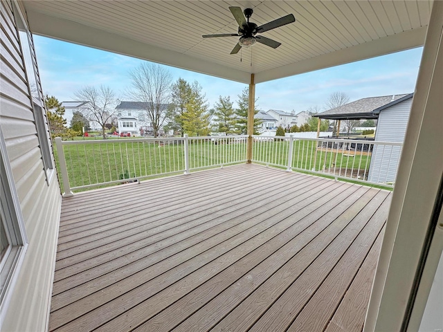 wooden deck with a yard and ceiling fan