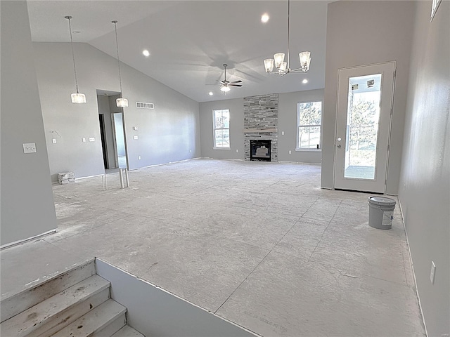 unfurnished living room featuring a stone fireplace, lofted ceiling, and ceiling fan