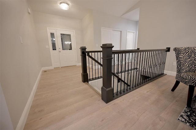 hallway featuring lofted ceiling and light wood-type flooring