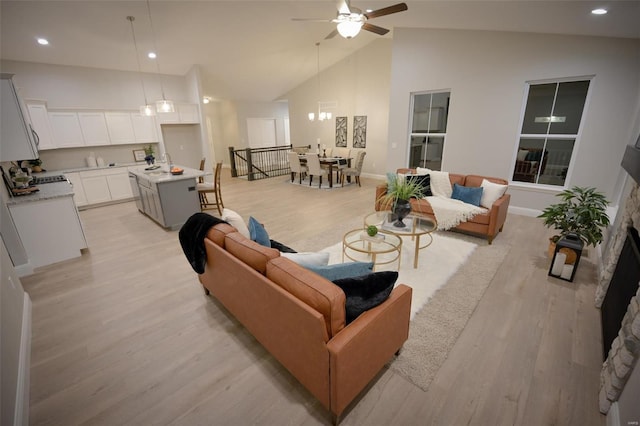 living room featuring ceiling fan, high vaulted ceiling, sink, and light hardwood / wood-style floors