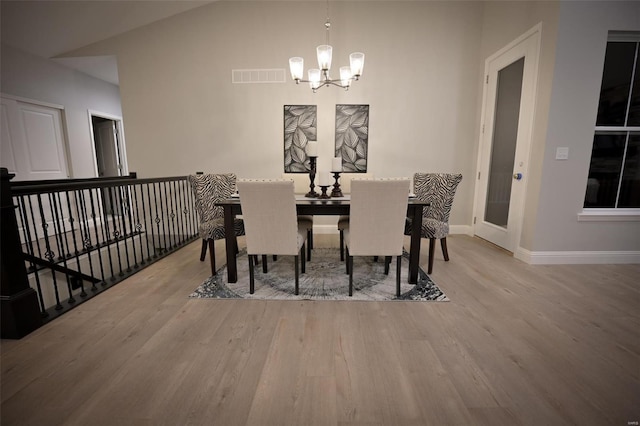 dining room featuring lofted ceiling, a notable chandelier, and light hardwood / wood-style floors