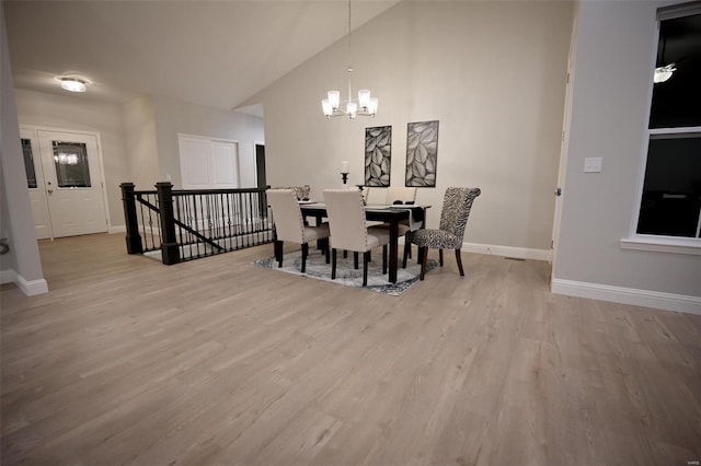 dining room featuring vaulted ceiling, light hardwood / wood-style flooring, and a notable chandelier