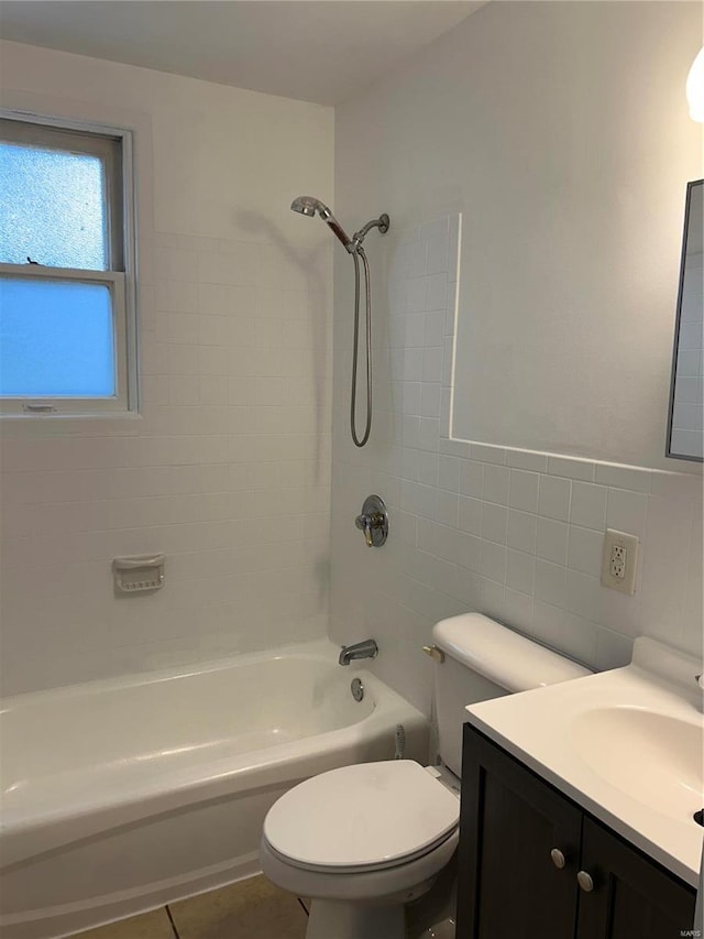 full bathroom with tile walls, vanity, tile patterned flooring, toilet, and tiled shower / bath