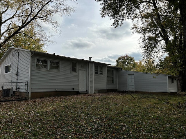 back of house featuring central air condition unit and a yard