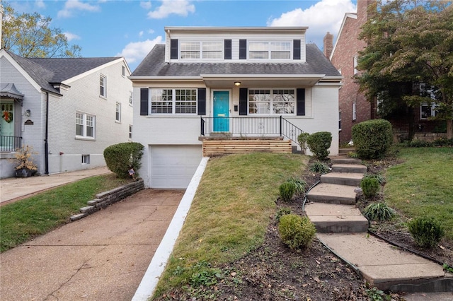 view of front of property featuring a garage, covered porch, and a front lawn