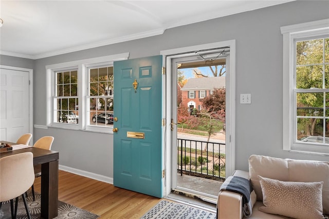 entryway featuring a wealth of natural light, crown molding, and light hardwood / wood-style flooring