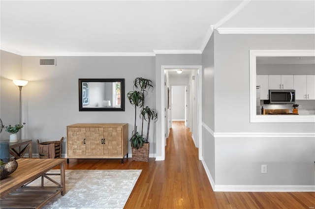 corridor featuring hardwood / wood-style floors and ornamental molding