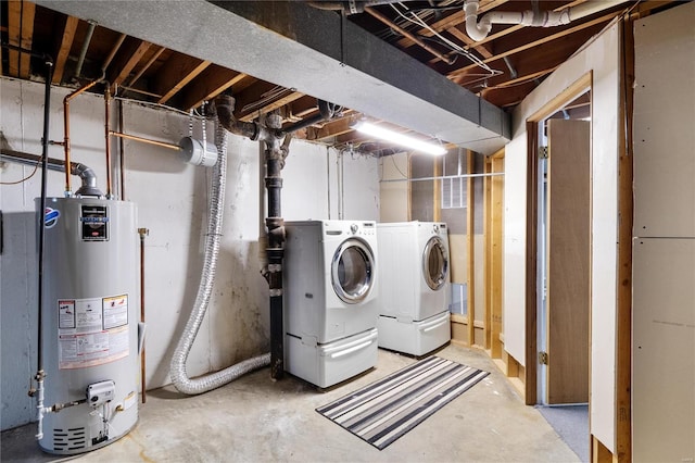 clothes washing area featuring water heater and independent washer and dryer