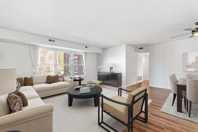 living room featuring wood-type flooring and ceiling fan