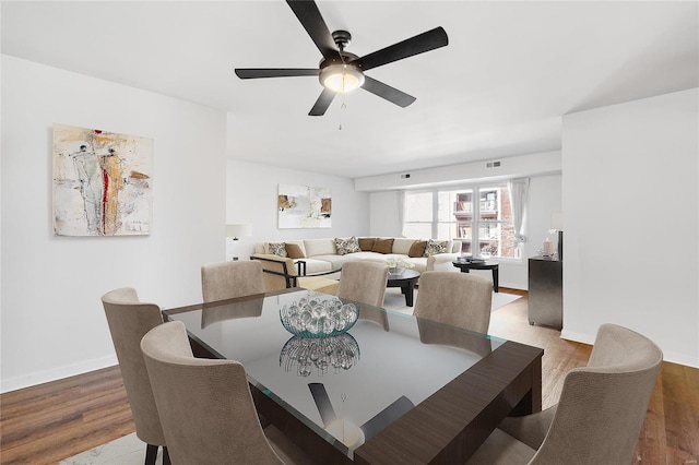 dining space with ceiling fan and wood-type flooring