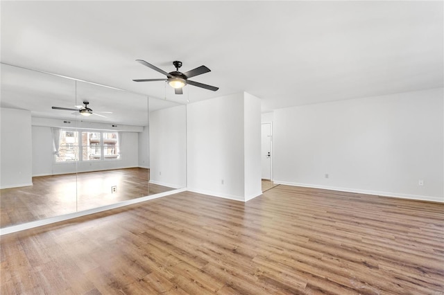 empty room with ceiling fan and light hardwood / wood-style floors