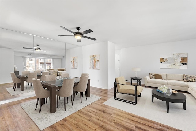 dining space with ceiling fan and light hardwood / wood-style flooring